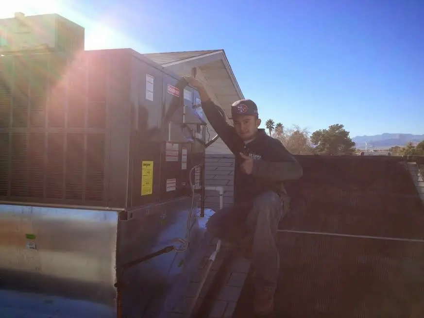 HVAC technician performing AC Tune-Up on a rooftop unit in Freeport